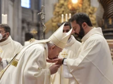 Pope Francis kisses the hands of a newly ordained priest in St. Peter’s Basilica, April 25, 2021.